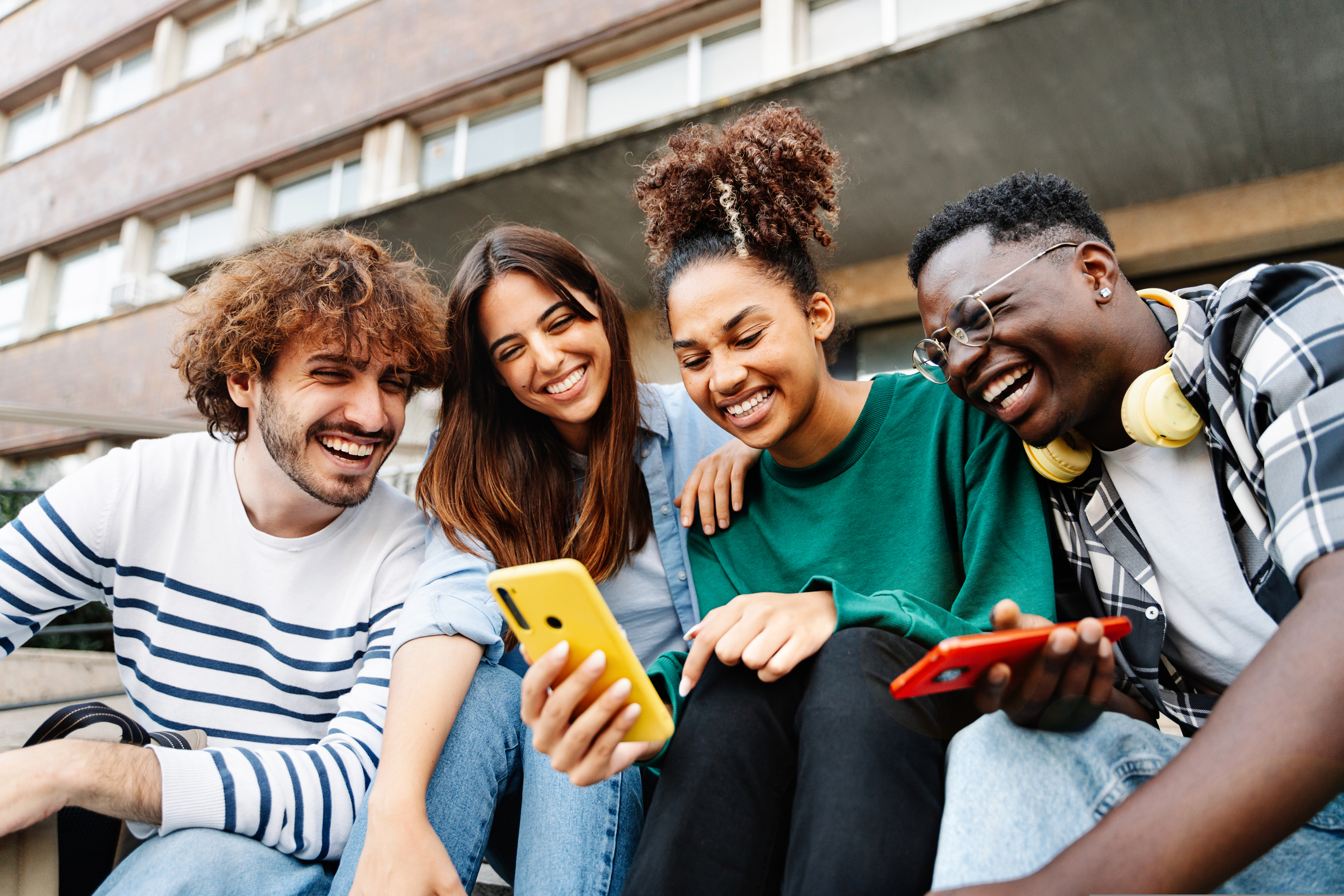 Group of students looking at phone smiling